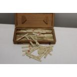 A box full of vintage ivory game markers