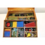 A wooden box full of assorted Meccano parts etc