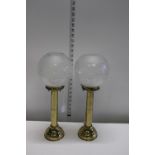 A pair of gilt metal candle holders with etched glass shades