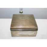 A hallmarked silver cigarette box with engine turned decoration & monogram to the lid. With a box