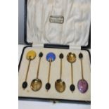 A cased set of six hallmarked silver & gilt coffee spoons with guilloche enamel decoration.