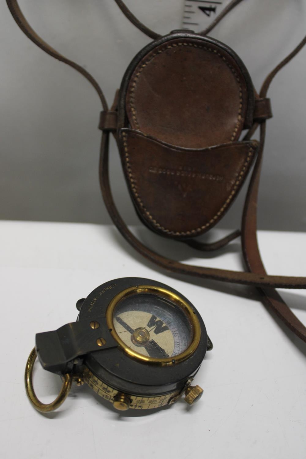 A WW1 military compass with leather case and shoulder strap. dated 1916. Compass by E R Watts & Sons