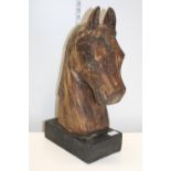 A hand carved wooden horses head sculpture