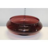 A large plum coloured glass bowl