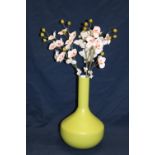 A stylish green vase with fake flowers