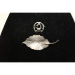 A hallmarked silver leaf brooch and sterling silver horseshoe brooch