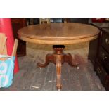 A Victorian round top table on cabriolet legs & castors