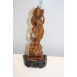 A carved figure on stand of oriental origin