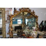 A gilt framed ornate over mantle mirror with foliage decoration 117x122cm collection only