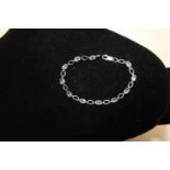 A 9ct white gold & blue topaz tennis bracelet