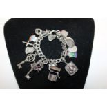 A sterling silver charm bracelet with 18 assorted charms