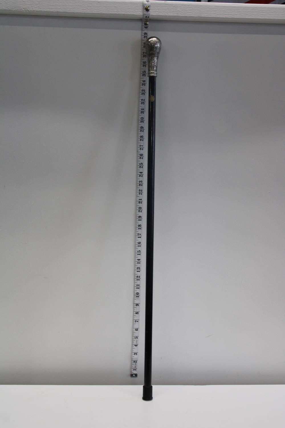 A vintage white metal topped walking cane. Postage unavailable