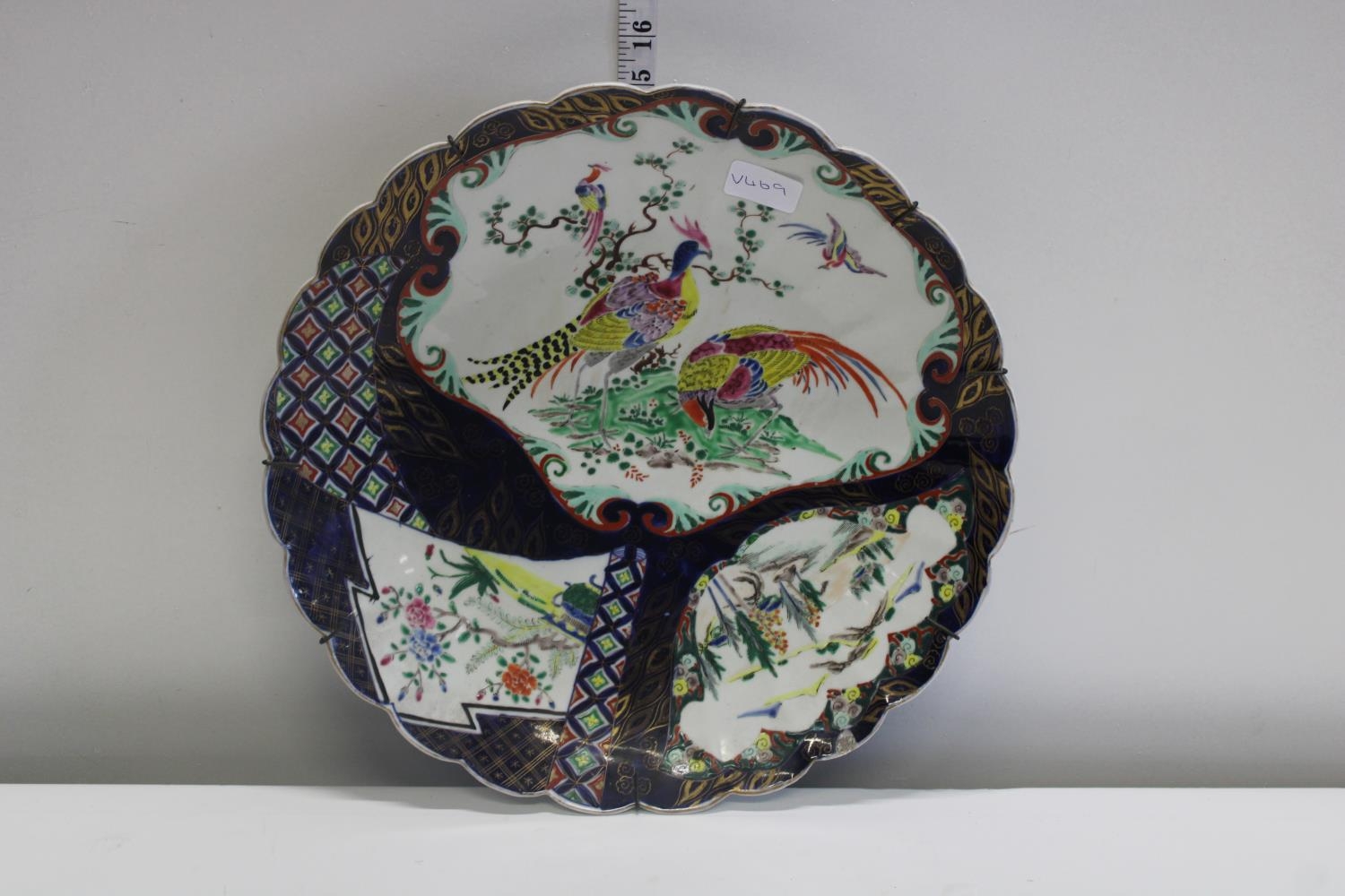 A antique Oriental hand painted pottery charger. Signed to the reverse