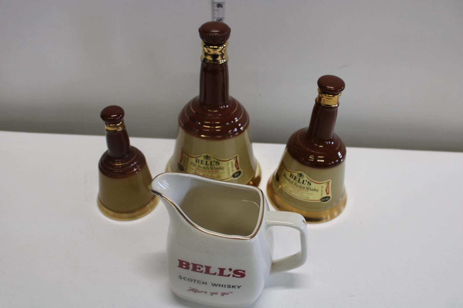 Three empty Wade bells decanters & Wade Bell's water jug