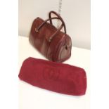 A Cartier Boston Bag – Oxblood leather. Each end of the bag is embossed with the signature