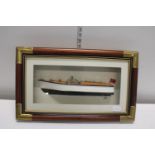 A model speed boat in a wall hanging display case