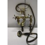 A vintage 1930's brass bath mixer tap with shower attachment