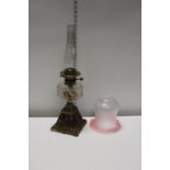 An antique brass and glass oil lamp with a Hinks burner