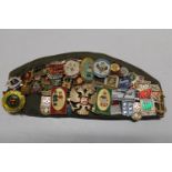 A military cap with a large collection of assorted pin badges