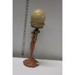 An art deco style figurine holding an ostrich egg