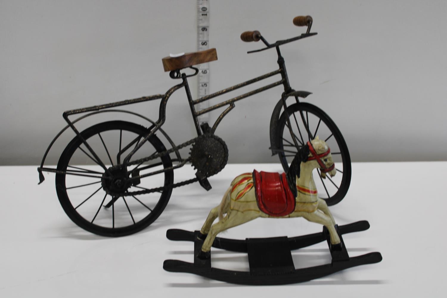 A metal bicycle model and vintage miniature wooden rocking horse