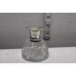 A silver topped perfume bottle with glass stopper