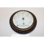 A antique barometer with a rope form oak case.