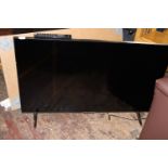 A Panasonic flat screen TV on stand with remote. Postage unavailable