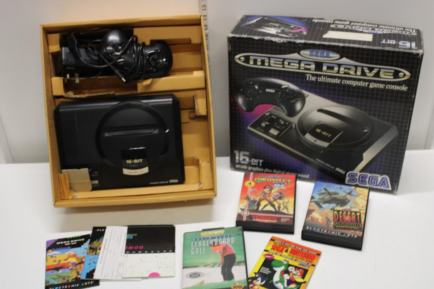 A boxed Sega Mega drive with an assortment of games and accessories