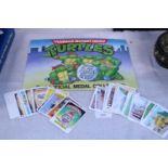 A Teenage Mutant Turtles Coin album and selection of trading cards