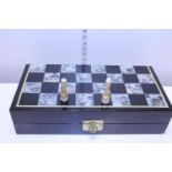 A MOP inlaid chess board and pieces