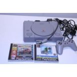 A Sony Playstation One with controllers and games