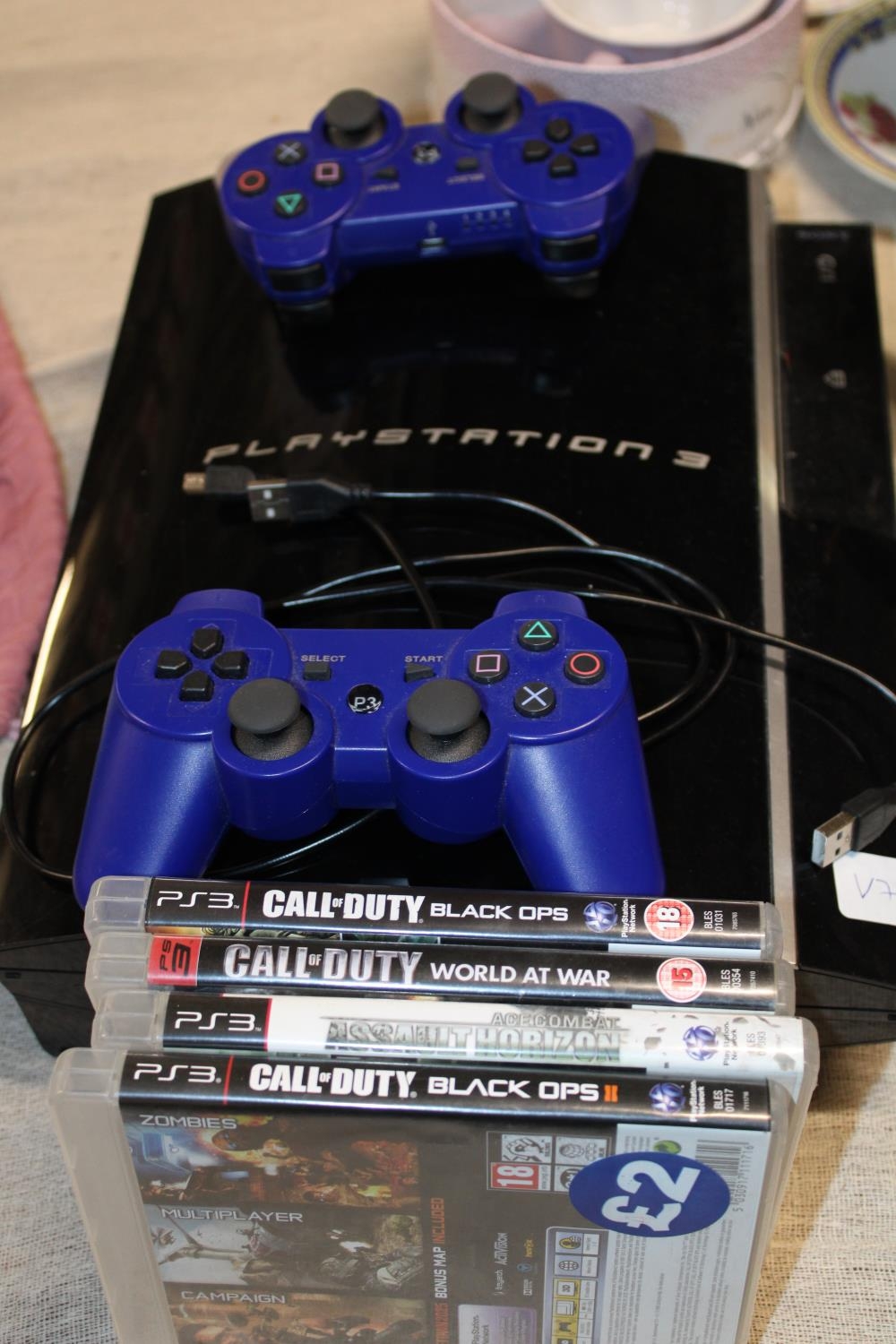 A Playstation 3 with controllers and games