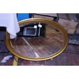 A gilt framed oval mirror with bevelled edge glass, Collection only