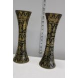 A pair of heavy brass vases with black and enamel inlay