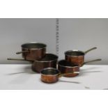 A set of five copper and brass pans