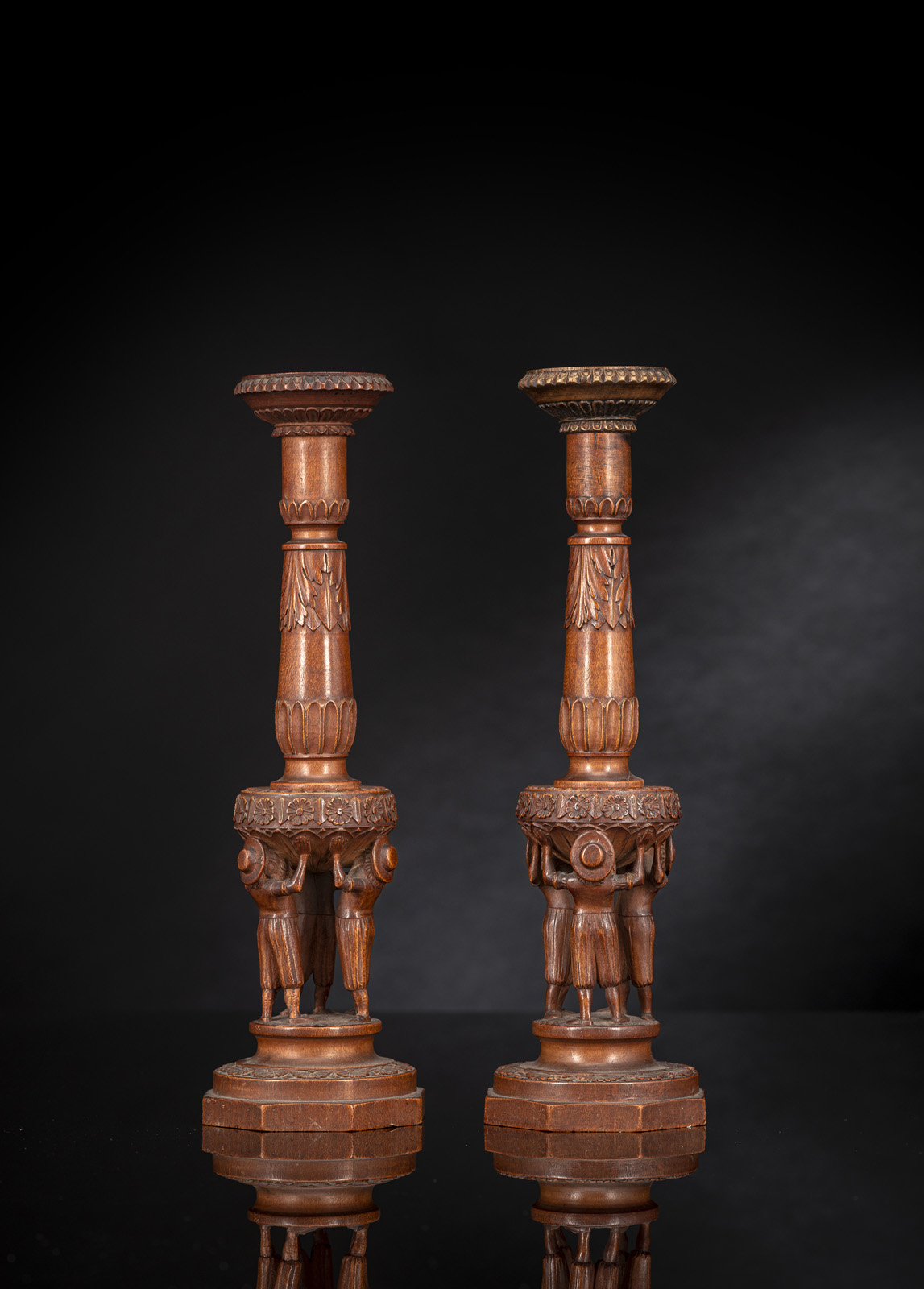 A PAIR OF FIGURAL CARVED FRUITWOOD CANDLESTICKS