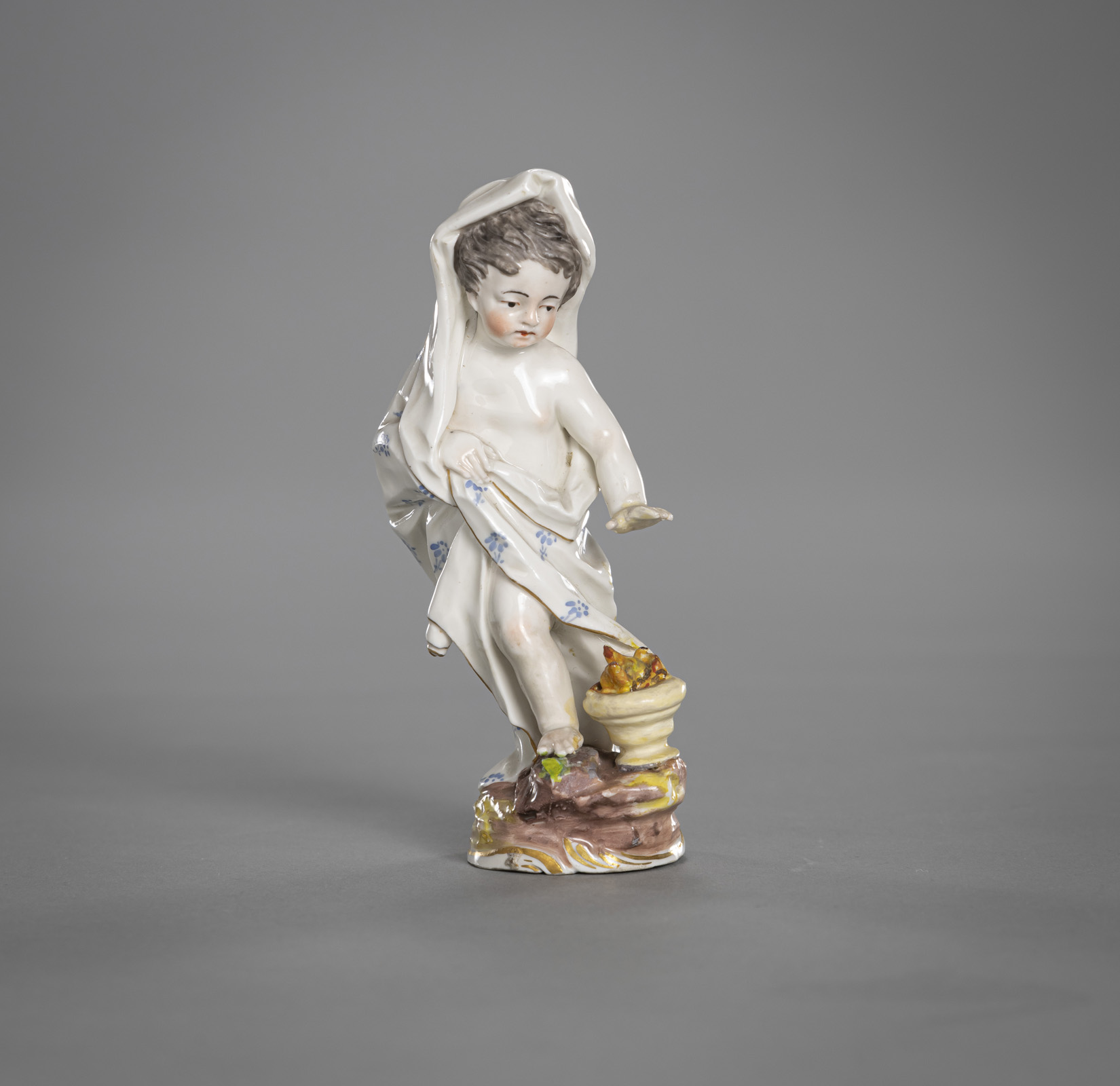 A FIGURINE OF A PUTTO DEPICTING THE WINTER