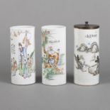 Drei zylindrische polychrom bemalte Hutständer aus Porzellan mit Figuren- und Landschaftsdekor