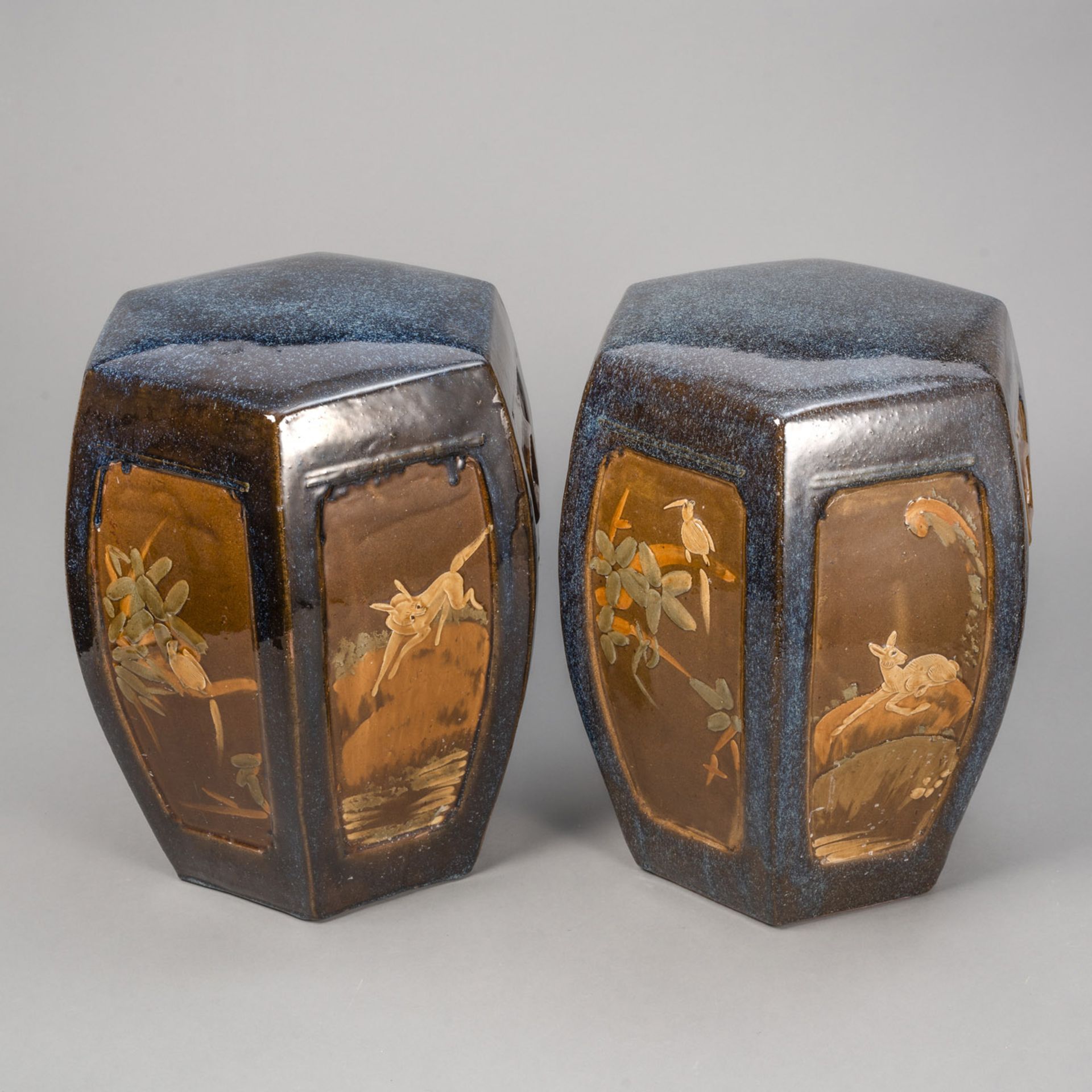 A PAIR OF SHIWAN WARE STOOLS WITH VARIOUS ANIMALS IN RELIEF