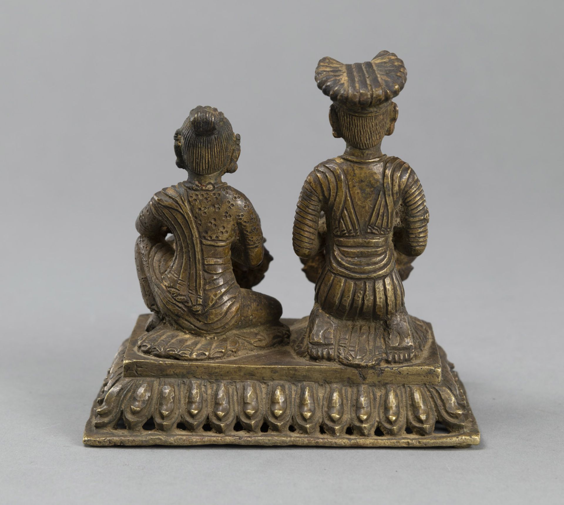 A GILT-COPPER OILLAMP WITH A KNEELING WORSHIPPING COUPLE ON A RECTANGULAR LOTUS BASE - Image 3 of 4