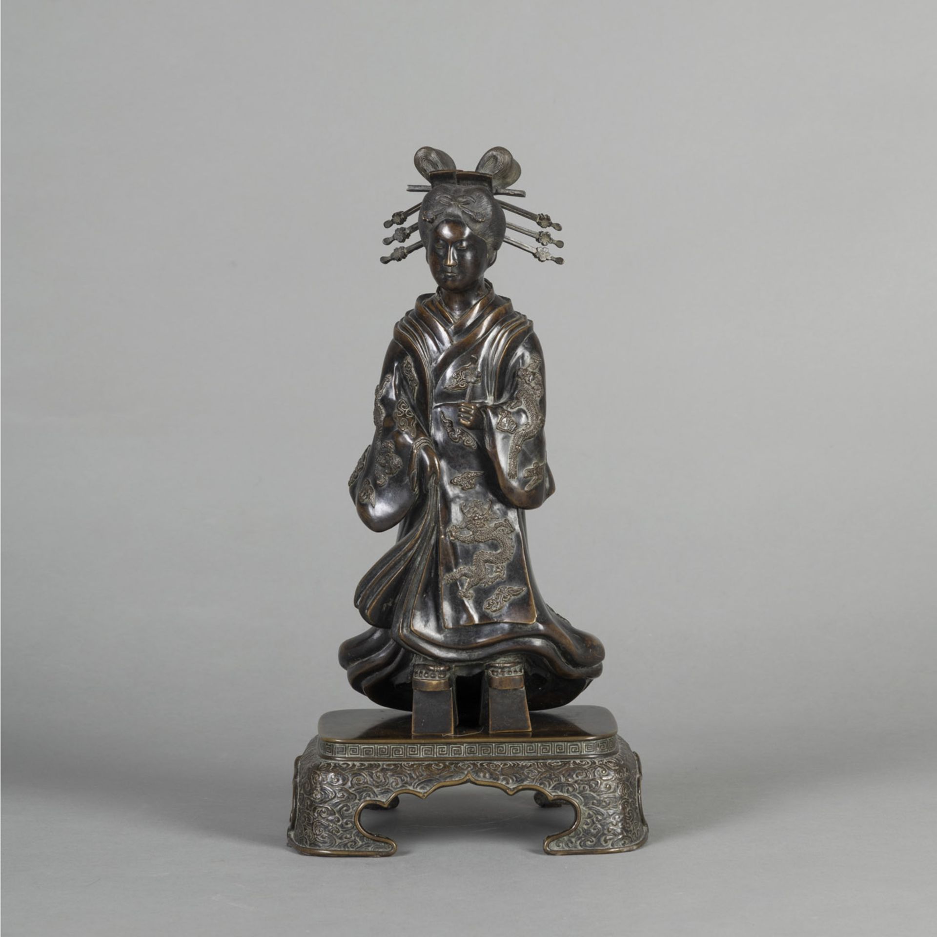 A TWO-PART BRONZE OKIMONO OF A GEISHA WEARING A DRAGON KIMONO