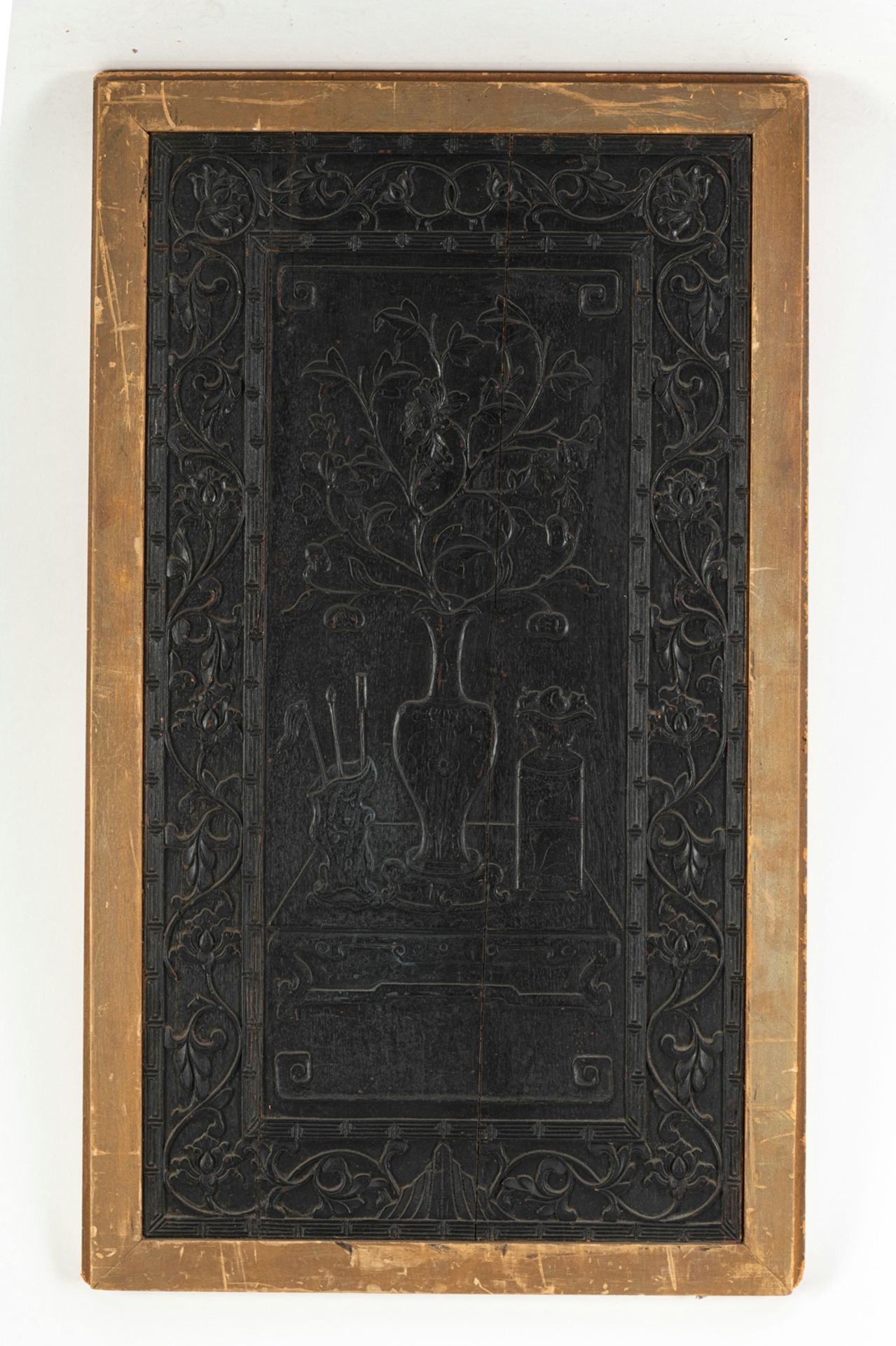 A CARVED WOOD PANEL WITH A STILL LIFE OF VASES ON A TABLE