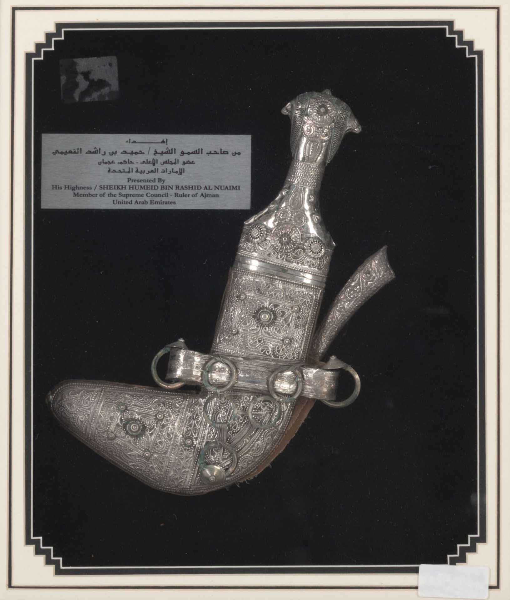 A JAMBIYA DAGGER WITH SILVER APPLIQUE WORK WITHIN A FRAME