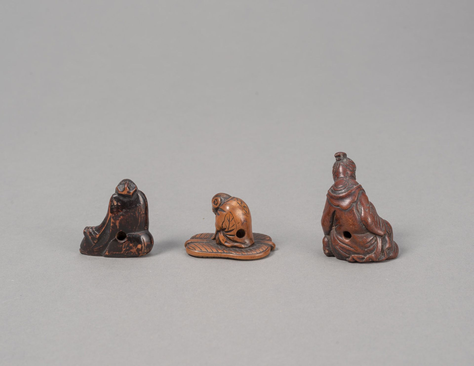 Drei Netsuke aus Buchsbaum: ruhender Gelehrter, Affe auf Palmblatt und stilllende Mutter mit Kind - Bild 2 aus 3