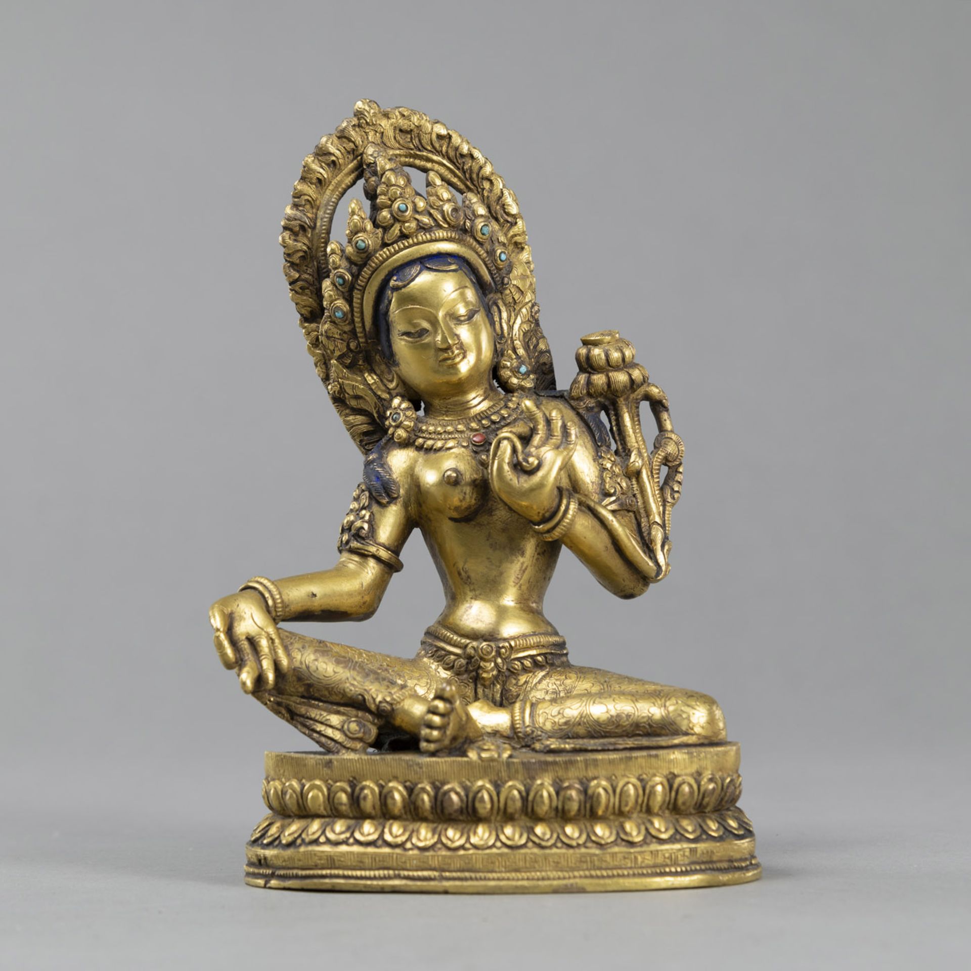 A SEATED GILT BRONZE SEATED TARA WITH STONE INLAY