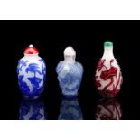 Drei Snuffbottles aus Pekingglas mit rotem, hellblauem bzw. königsblauem Überfang