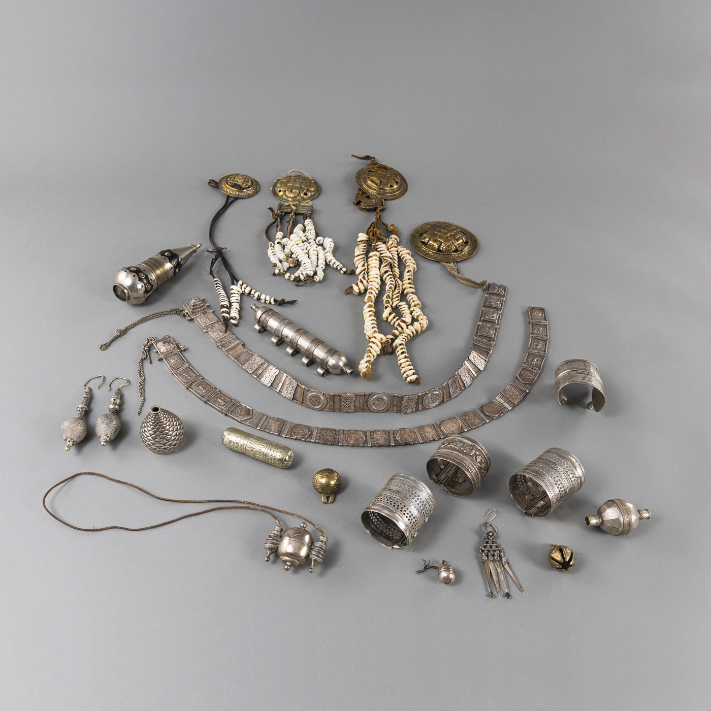 A GROUP OF 22 PIECES OF JEWELRY, PARTLY SILVER: BELTS, BRACELETS, AMULETS AND MEDALLION CHAINS