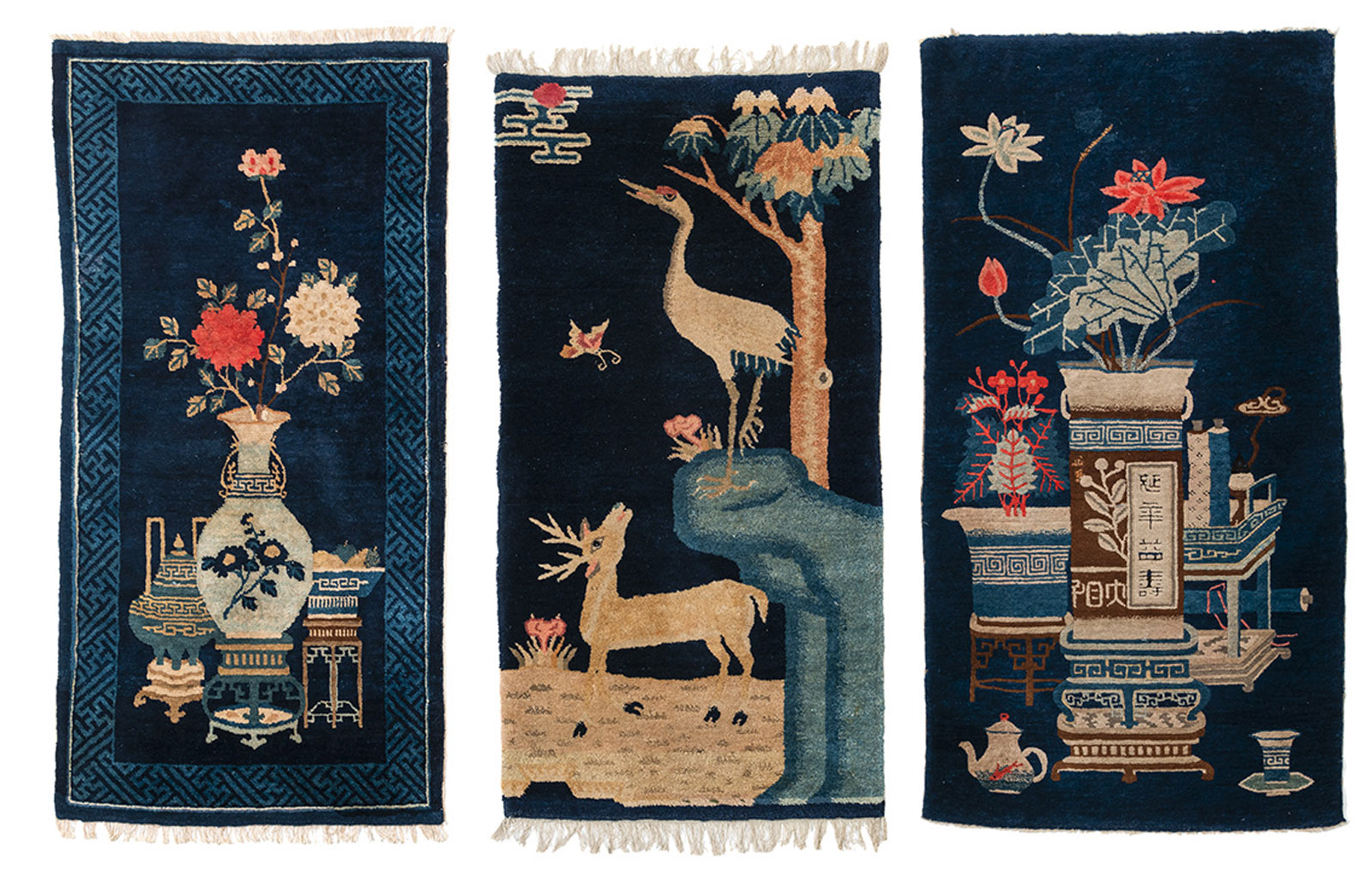 THREE DARK BLUE CARPETS DEPICTING ANTIQUES AND 'CRANE AND DEER' SYMBOLS