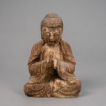 Figur des Buddha aus Holz mit Resten von Fassung